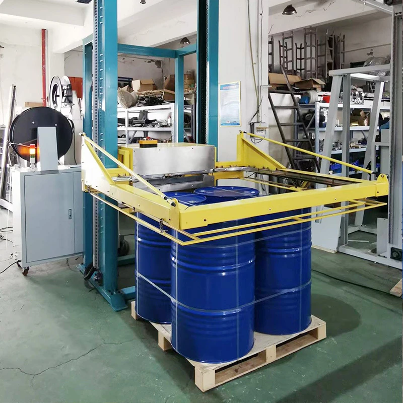 Yellow horizontal strapping frame positioned around blue drums on a pallet